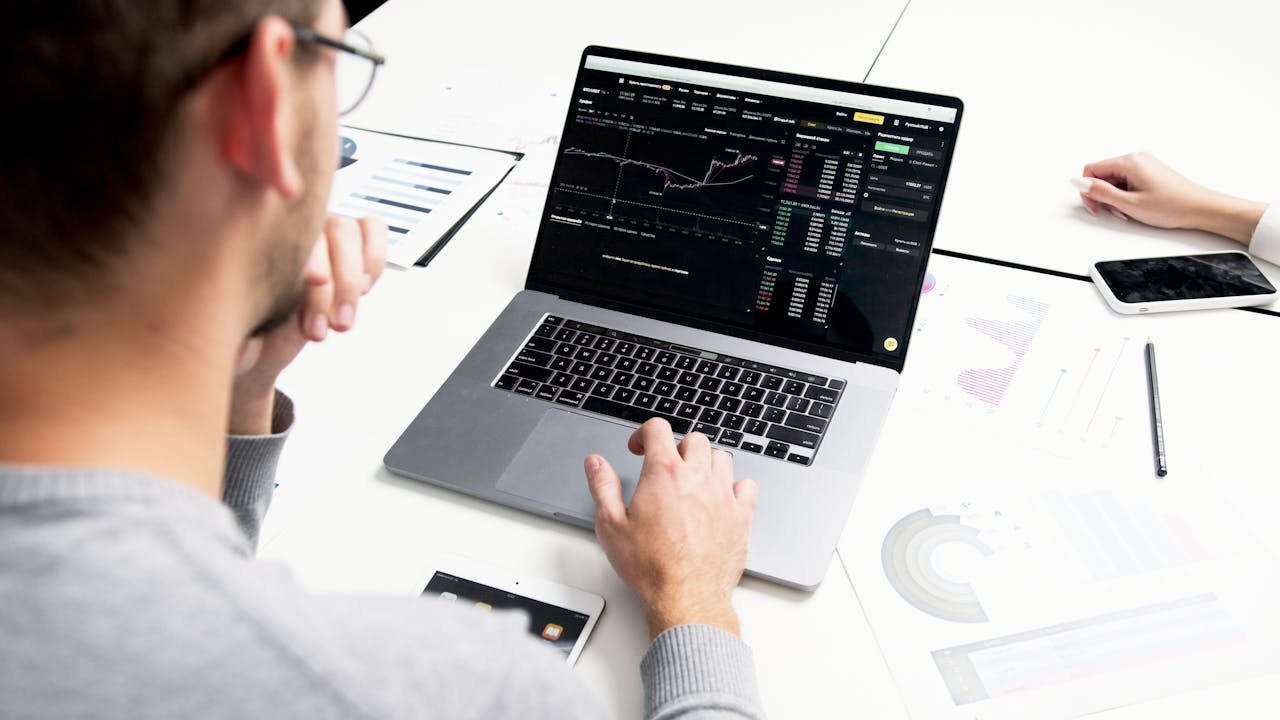services-03 Business professional analyzing stock market data on a laptop for investment insights.